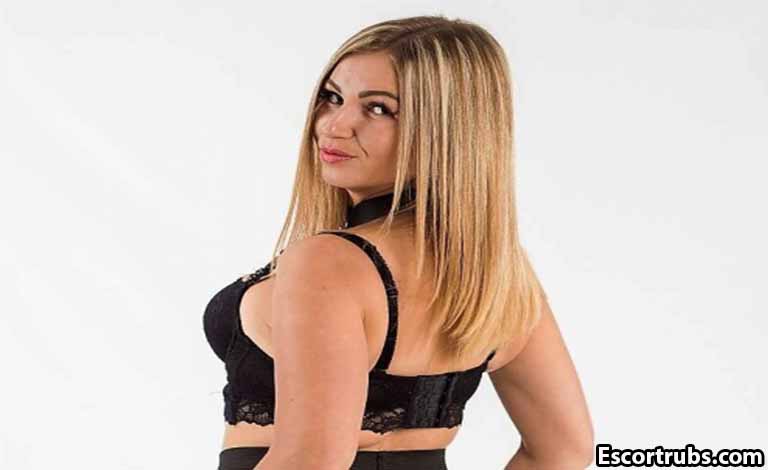 Get Glowing: The Power of a Good Body Scrub Massage Explained Woman in black lace lingerie posing with her back turned, looking over her shoulder at the camera.